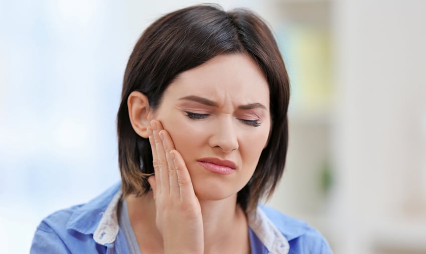 beautiful young woman suffering from jaw pain