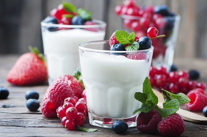 A photo of yogurut in a cup with berries