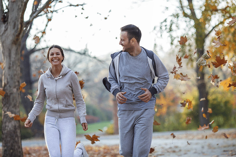 A young couple running and smiling together in Burke, Virginia