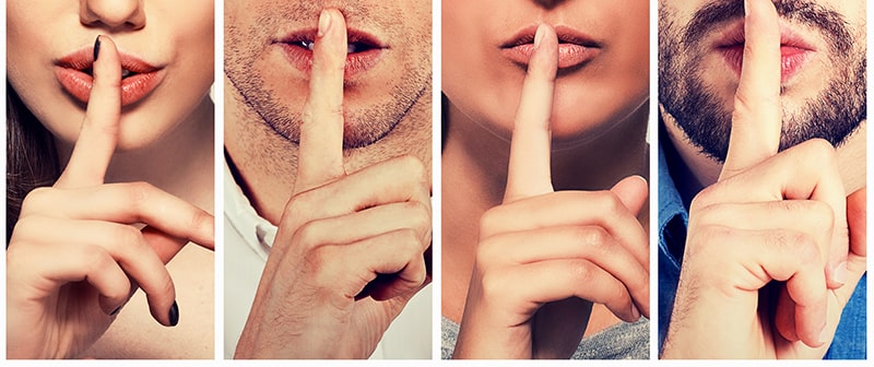 Four individuals with their finder up to the lips as if to cover up a secret.